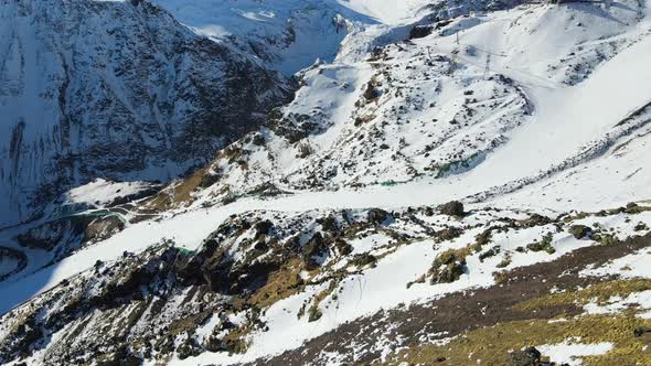 Ski Slope with Downhill Skiers Among the Gray Rocks on the Slopes of Elbrus alt