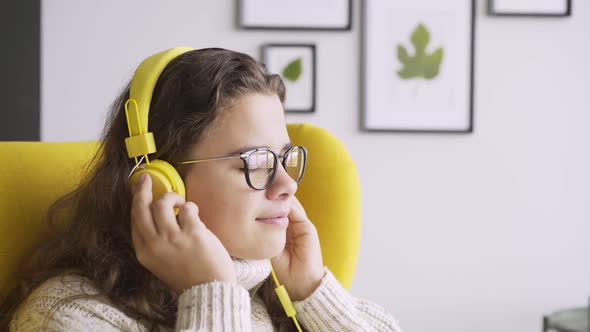 Woman Puts on Headphones and Listening Music