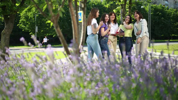 Smiling Students with Papers Putting Hands on Top of Each Other alt