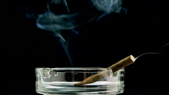 A Man Smokes A Cigarette On A Black Background Close Up Of An Ashtray And A Cigarette.