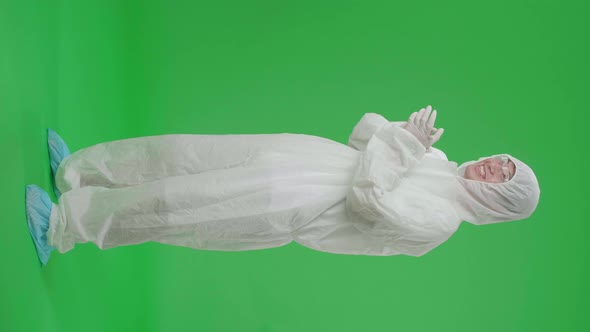 Side View Of Full Body Asian Man Wear Uniform Ppe And Clapping His Hands In The Green Screen Studio alt