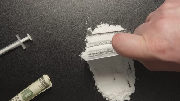 Drugs - Man does a lines of heroin by plastic card