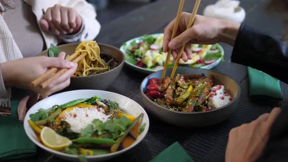 Lunch Break at Oriental Cuisine Restaurant. Meals Served in Colorful Bowls on Black Wooden Table.  alt
