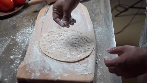 Men's Hands Sprinkle Flatbread with Flour for the Video About Food alt