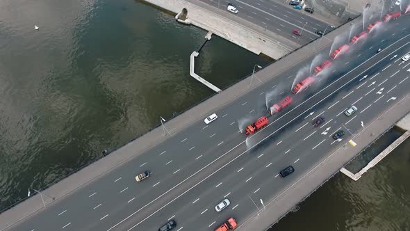 Several Special Watering Machines Lined Up in a Row Are Pouring Water on the Bridge of One of the alt