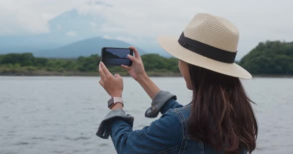 Woman take photo with the mountain fuji in Japan alt