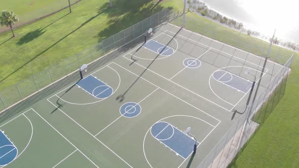 Super smooth drone flight turning over 3 perfectly painted public blue basketball courts alt