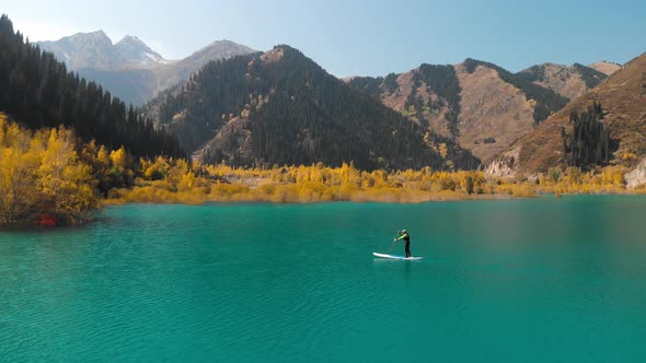 Man Is Paddling on Sup Board in the Mountain Lake alt