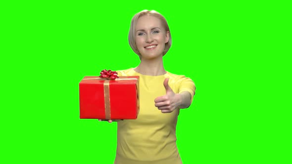 Happy Middle Aged Woman with Red Gift Box and Thumb Up alt