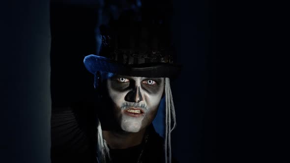 Sinister Man with Halloween Skeleton Makeup Quickly Appears From Dark Corner, Trying To Scare alt