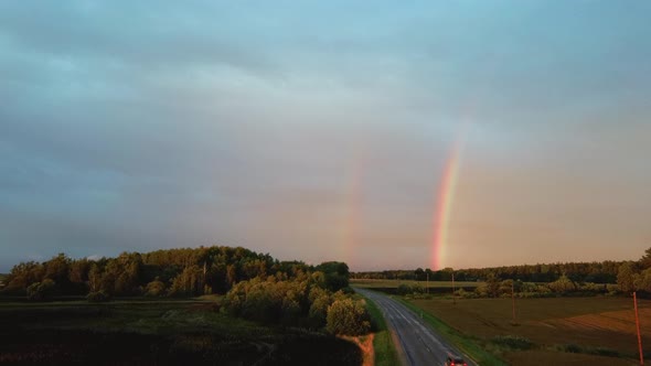 Dark Thunderstorm Clouds and Double Rainbow Over Forest and Wheat Field, Areal Dron Shoot. alt