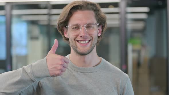 Portrait of Young Businessman Showing Thumbs Up Sign alt