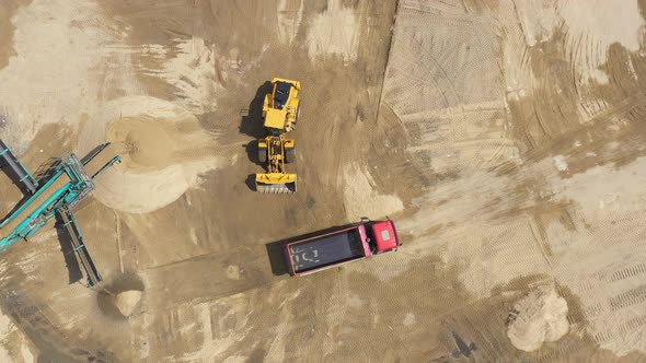 Aerial view loading bulldozer in open air quarry. Sand mining industry. Bulldozer machine. Crawler b alt