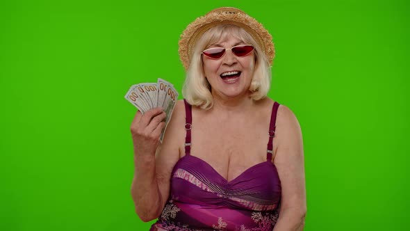 Rich Senior Woman Tourist with Cash Fan Enjoying Financial Independence Waving Currency Dollar Bills alt