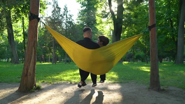 Happy couple relaxing in a hammock alt