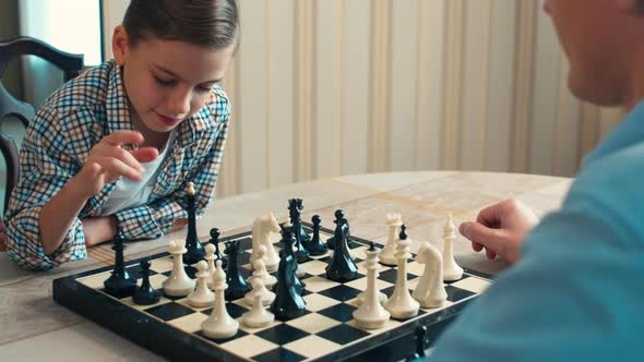 Caucasian boy playing chess with his dad