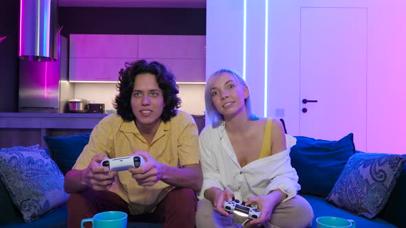 Handsome Young Man Teaching How To Play the Video Games To His Girlfriend on the Couch Concept About alt