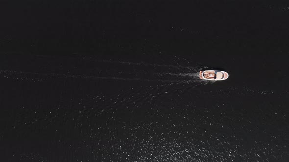 Aerial: top down view of motorboat on water, summertime leisure activity alt