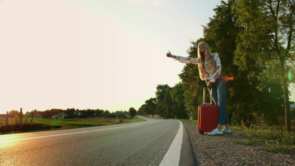 A Woman Traveler, WALKING ON THE ROAD. Tired Young Woman Backpacker, Starting a Journey on a Sunlit alt