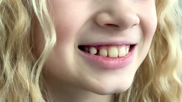 Blonde Caucasian Baby Girl Shaking Tongue Milk Tooth in Mouth Children Dentistry Stomatology and alt