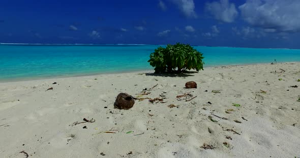 Wide aerial tourism shot of a paradise sunny white sand beach and blue sea background in vibrant 4K alt