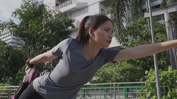 Athlete young Asian woman stretching legs and warming before running.