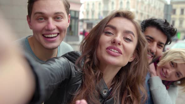 Friends making video call or recording vlog outdoors front view.  alt