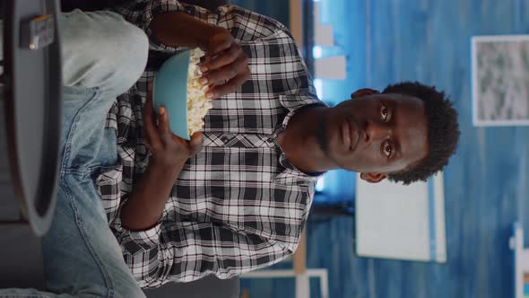 Vertical Video POV of Interracial Couple Watching Movie on TV with Snack alt