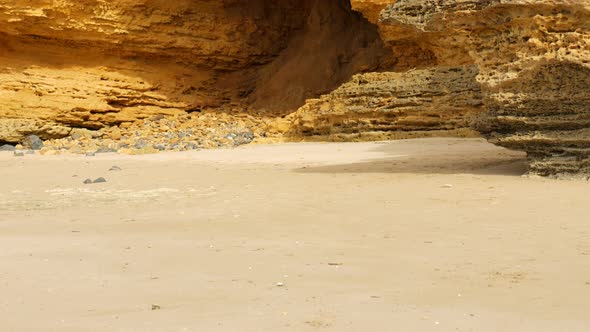 Large cave with lots of rocks on a costal beach. PAN UP SHOT alt