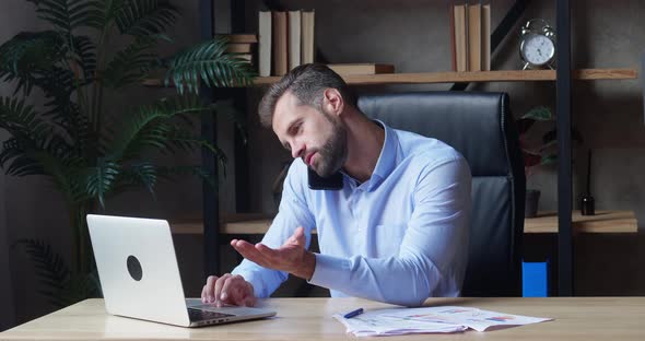 Businessman Using Laptop and Calling Smartphone in Same Time Working Overtime in Business Startup alt