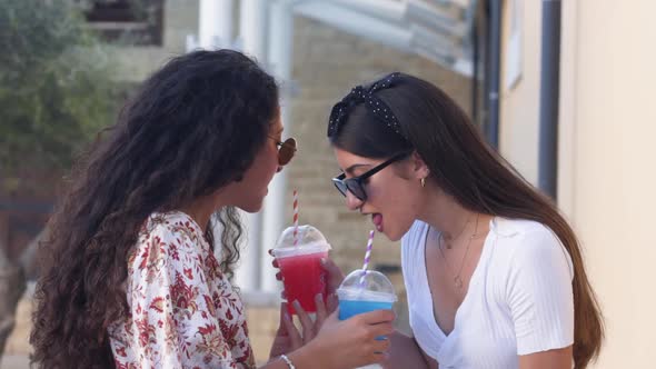 Young Multiethnic Teenage Girls Drinking Colorful Drinks in City