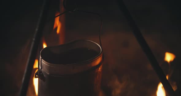 Close-up View of Pot on Campfire on Camping Trip at Night. Boiling Water, Cooking Dinner on alt