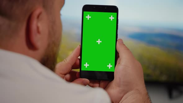 Man Watching on Smartphone Green Screen for Copy Space Chroma Key alt