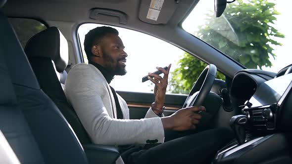 African American Guy Sitting in His Luxurious Vehicle and saying on mobile alt