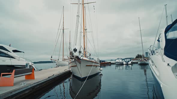 Blue Sailboat Moored to a Pier in Yacht Marina at Sunset alt