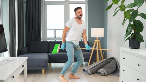 Man Cleaning the House and Having Fun Dancing with a Broom alt