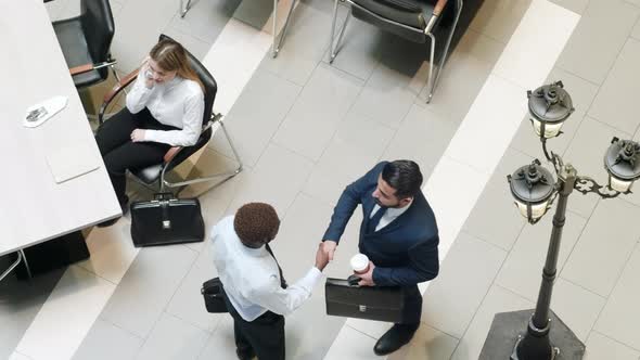 Businessmen greeting each other in canteen