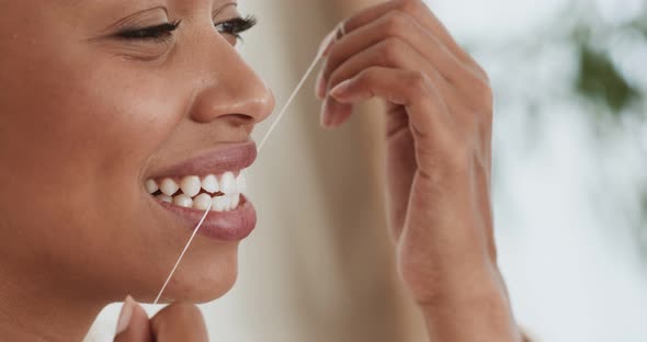 Young Black Woman Flossing Her Teeth with Tooth Floss at Home, Close Up Portrait alt