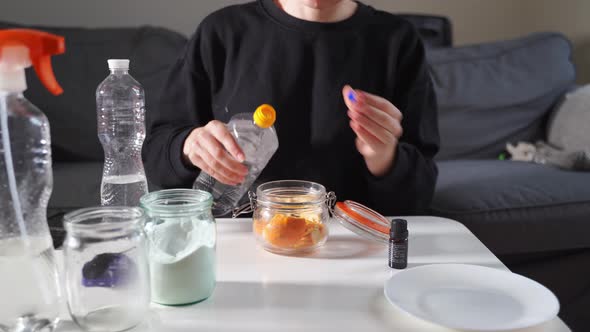 Millennial Girl Doing Diy Cleaning Spray at Home with Vinegar Soda and Lemon alt