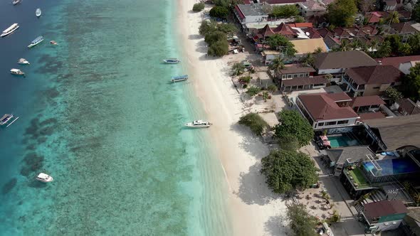 Aerial shot of Gili Trawangan Beach with clear water,parking yachts and luxury hotel resort. alt
