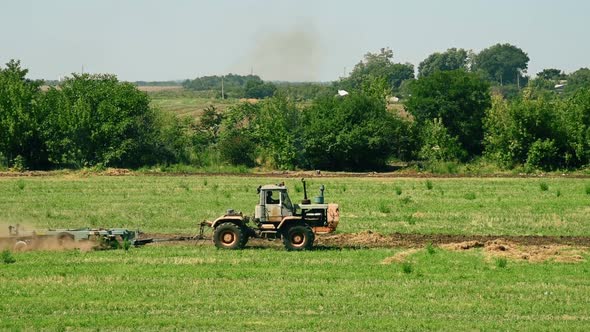 Tractor Cultivating Field At Spring