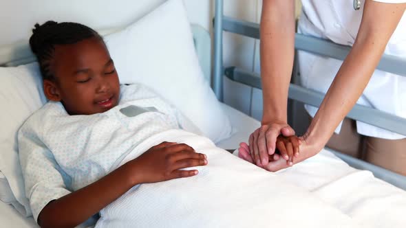 Female doctor consoling sick girl alt