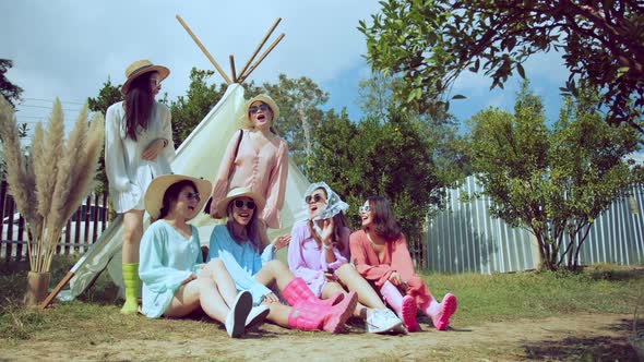 Asian friends wearing colorful casual dress camping or picnic cheerful fun together in garden