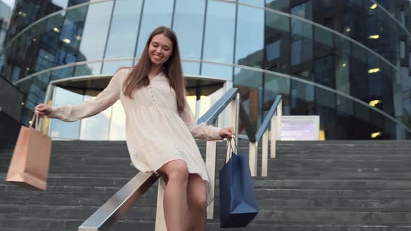 Woman Sliding Down Handrail after Shopping alt