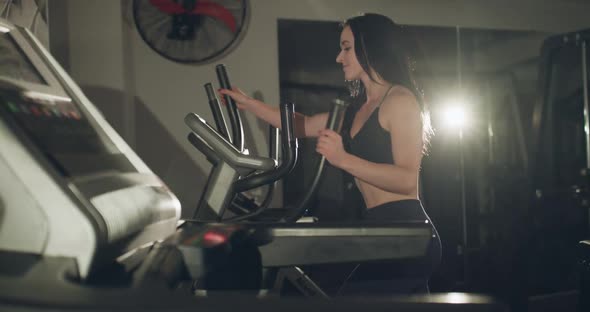 Cheerful Woman Smiling While Working Out on Steppers in a Gym alt