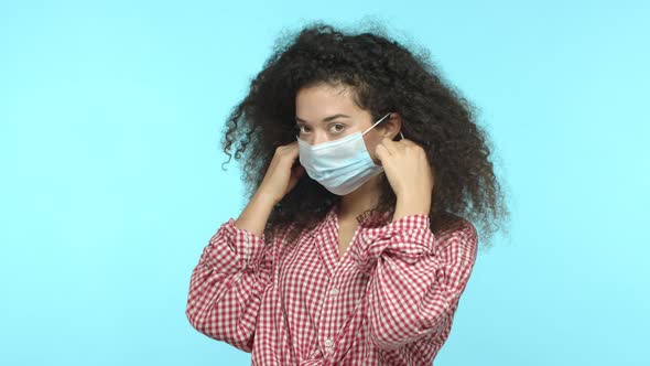 Young Woman Takes Off Medical Mask