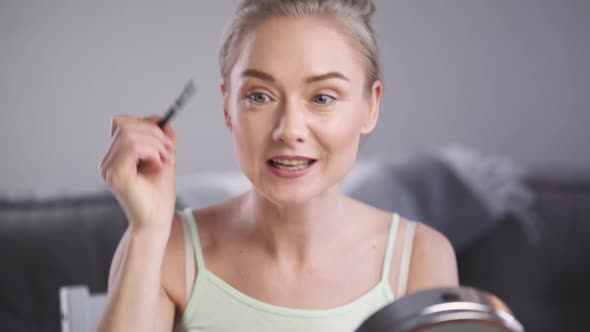Portrait of Female Beauty Blogger Woman Shows How to Apply Makeup on Face Makes a Stream on Social alt