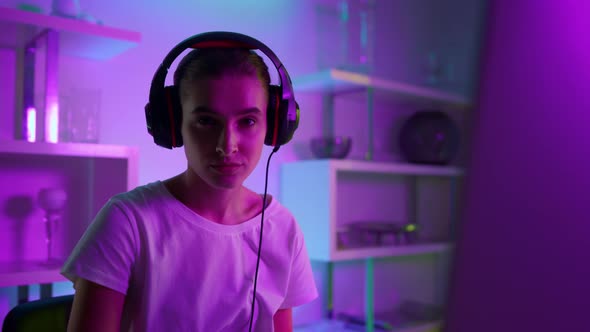 Closeup Beautiful Girl Gamer in Neon Lights at Home alt