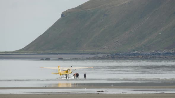 People Unloading From Parked Bush Plane on Water alt