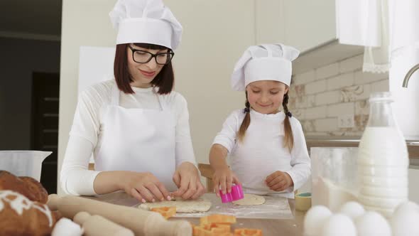 Little Girl Using Plastic Forms to Cut the Dough alt